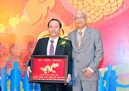 Bác sĩ Bùi Cúc (trái) nhận kỉ niệm chương Doanh nhân thành đạt – Doanh nghiệp phát triển bền vững và Tiến sĩ Cao Sĩ Kiêm (phải)
